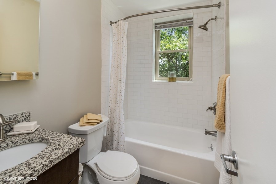 a bathroom with a bathtub and toilet in a 555 waverly unit